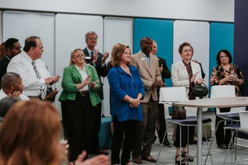 Attendees clapping at the center ribbon cutting ceremony.